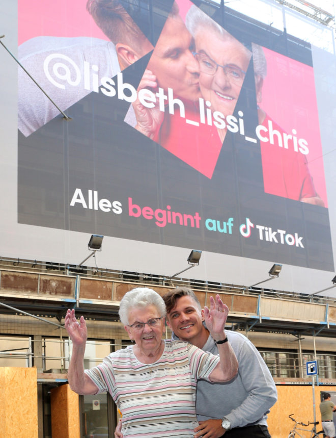 Christian "Chris" Kroemer zeigt seine Großmutter Elisabeth (Lissi auf  TikTok) die brandneue Werbekampagne in der Landwehrstrasse. Dafür kamen die beiden aus ihrer Heimatstadt Nürnberg. Fotocredit: Gisela Schober/PR