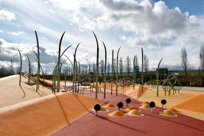 Im Hintergrund vom Wasserspielplatz kann man den Turm vom 39 Meter langen Fußgängersteg sehen, welcher alte und neue Stadtteile verbindet. Fotocredit: Schaller