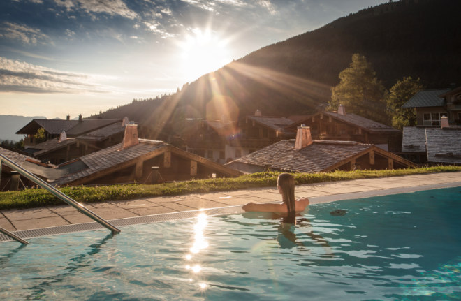 Mit den typischen niedrigen Dächern lehnen sich die erbauten Alpin Chalets an den Hochsattel von Oberjoch. Der Outdoor-Pool vom Panoramahotel Oberjoch.