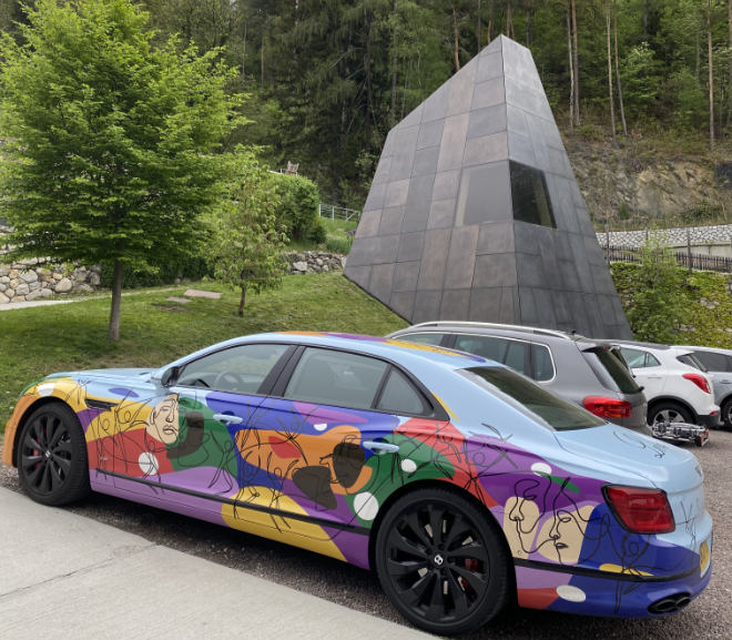 Hier steht der Bentley Unifying Spur auf dem Parkplatz vom Pacherhof. Der Monolith rechts im Bild gehört zum Weingut Pacherhof und gilt als Architektur-Meisterwerk.