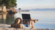 Young woman using laptop on a beach