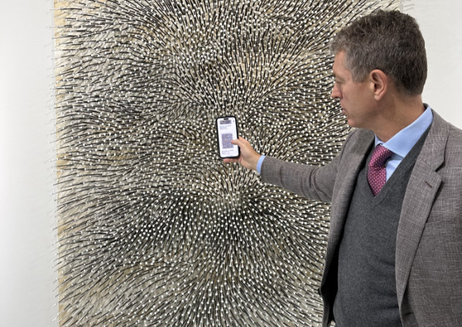 Robert Ketterer zeigt den digitalen Auktionskatalog. 2023 war ein berühmtes Nagelbild von Günther Uecker (95) in der Auktion.