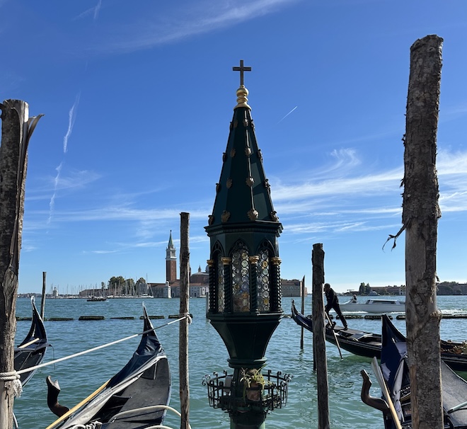 Venedig zwischen Glaube, Wasser und Geschichte: Eine kleine Votivlaterne am Canal Grande erinnert daran, wie eng die Lagunenstadt seit Jahrhunderten mit Schutzsymbolen, Schifffahrt und Spiritualität verbunden ist.