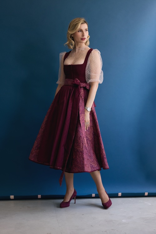 TraumTrachten-Gründerin Victoria Kopets präsentiert ein Dirndl in Bordeaux- und Rosétönen – modern interpretiert, feminin und wandelbar.