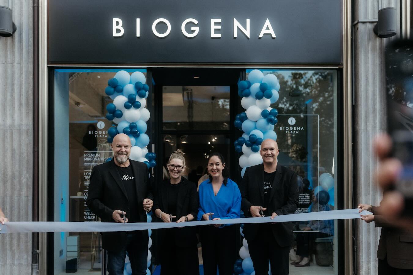 Dr. Albert Schmidbauer, Dr. Christina Schmidbauer, Julia Hoffmann und Stefan Klinglmair beim Banddurchschnitt vor der neuen BIOGENA Plaza am Münchner Maximiliansplatz.