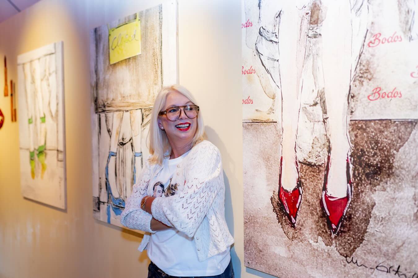 Designerin Ute Nonnenmacher neben ihren großformatigen Illustrationen im Bodos.