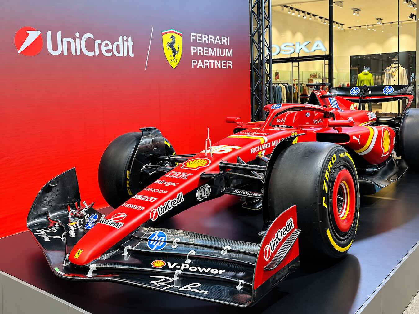 Rotes Ferrari-Formel-1-Showcar schräg von vorne auf einer Ausstellungsplattform in den Münchner Fünf Höfen.