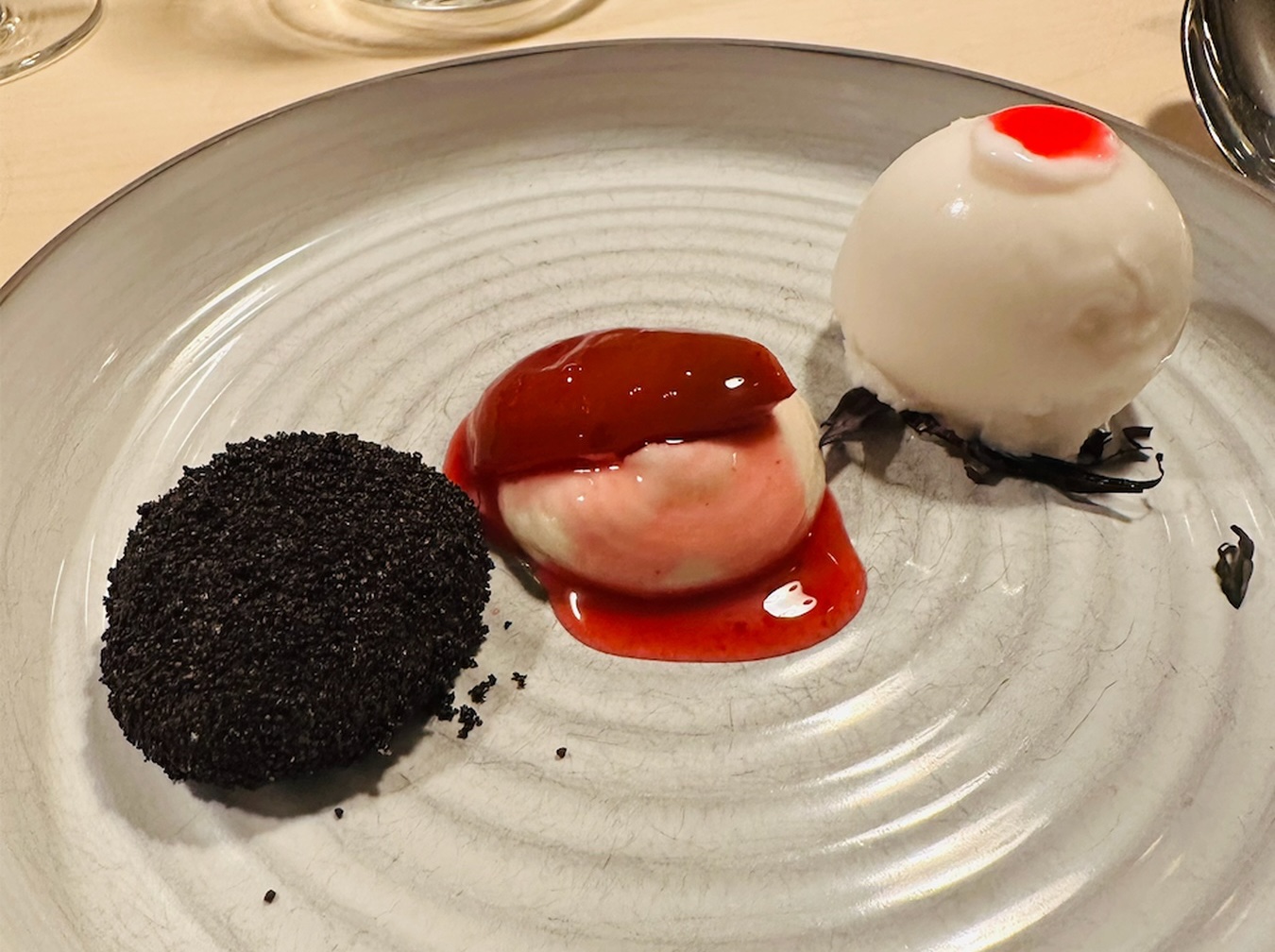 Amazake-Sorbet mit pochierten Pflaumen und Shiso im Restaurant Malva in München.