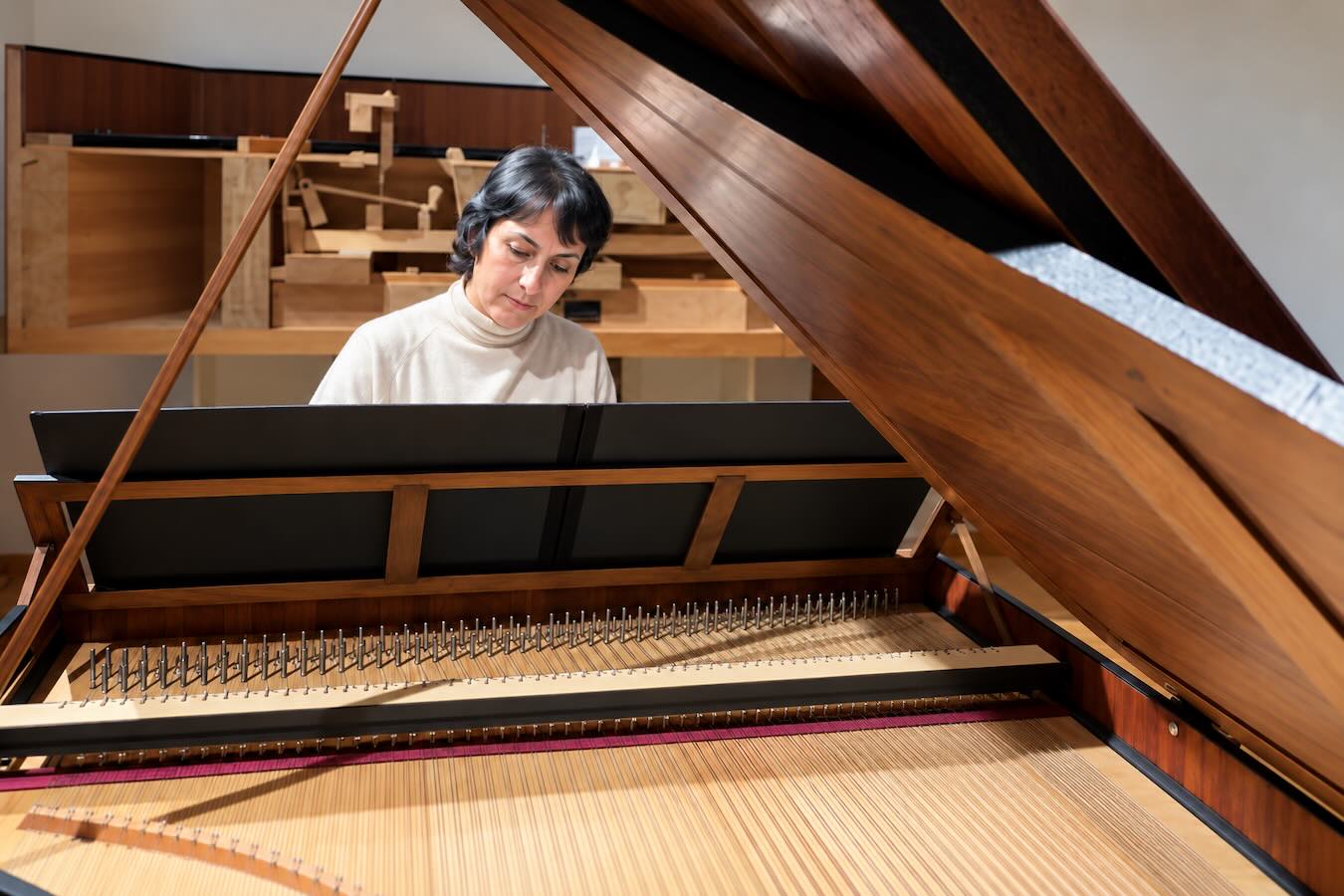 Varvara Manukyan am Nachbau eines historischen Hammerflügels im Greifenberger Institut, fotografiert über die Saiten und den Resonanzboden unter dem geöffneten Deckel.